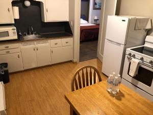 
a kitchen with a table and a refrigerator at Angeles Motel in Port Angeles
