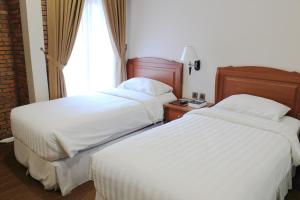 Tempat tidur dalam kamar di Thong's Inn Hotel Kualanamu