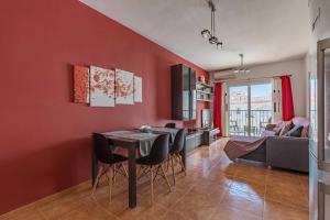 a kitchen and dining room with red walls and a table and chairs at Apartamento Steffi - Centro de Nerja in Nerja