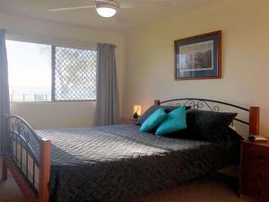 a bedroom with a bed with blue pillows and a window at The Poplars, 15,36 Magnus Street - Unit in a great complex with a pool and close to town in Nelson Bay +14 photos