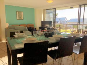 a dining room with a table with wine glasses on it at The Poplars, 15,36 Magnus Street - Unit in a great complex with a pool and close to town in Nelson Bay