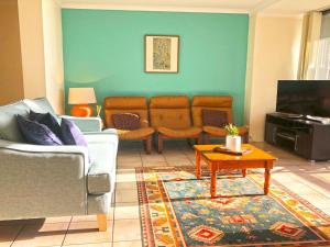 a living room with a couch and a tv at The Poplars, 15,36 Magnus Street - Unit in a great complex with a pool and close to town in Nelson Bay
