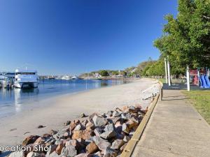 a beach with a pile of rocks next to a river at The Poplars, 15,36 Magnus Street - Unit in a great complex with a pool and close to town in Nelson Bay