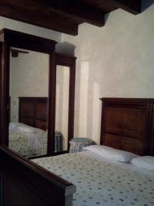 1 dormitorio con cama y espejo grande en Agriturismo Cascina Gilli, en Spino dʼAdda