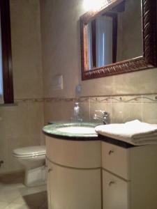 uma casa de banho com um lavatório, um WC e um espelho. em Agriturismo Cascina Gilli em Spino dʼAdda