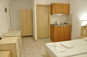 a kitchen with wooden cabinets and a counter top at Angelos Studios in Kos Town +13 photos