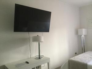 Cette chambre comprend un lit et une télévision murale. dans l'établissement Kaloneiro Guest House, à Corigliano dʼOtranto