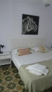 2 Betten in einem Zimmer mit einem Bild eines Tigers in der Unterkunft A3A Marina View in Torredembarra