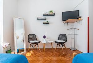 Vozilići的住宿－Apartmani Antonija，客厅配有两把椅子和墙上的电视