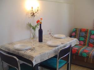 a table with two plates and a vase with flowers at Apartments Ana&Nešo in Pakoštane