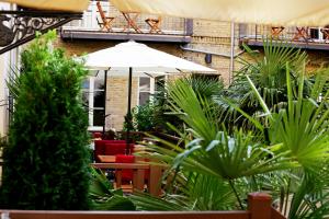 eine Terrasse mit einem Sonnenschirm, Stühlen und Pflanzen in der Unterkunft Garden Living - Boutique Hotel in Berlin