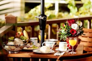 uma mesa com comida e bebidas e flores em Garden Living - Boutique Hotel em Berlim