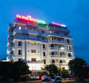 a large white building with neon signs on it at Kim Ngoc Khanh Hotel in Tuy Hoa