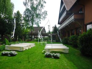 une rangée de tables et de chaises blanches dans une cour dans l'établissement Parkhotel Krone, à Emmendingen