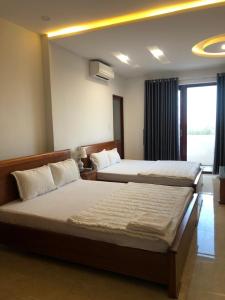 a hotel room with two beds and a window at Kim Ngoc Khanh Hotel in Tuy Hoa