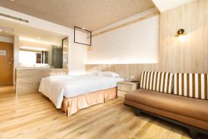 1 dormitorio con 1 cama y 1 sofá en Daniel Motel, en Xinying