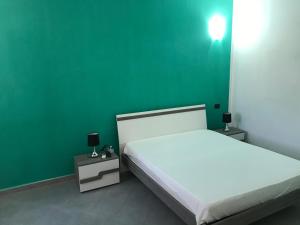 a green room with a bed and a green wall at Terrazza sul mare - Villa Tota - in Ardore Marina