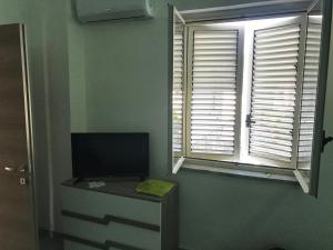 Habitación con ventana y escritorio con TV. en Terrazza sul mare - Villa Tota -, en Ardore Marina