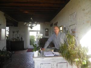 a man standing at a counter in a room at La Ferme des 3 Maillets in Avaray