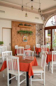 a dining room with a table and white chairs at Parthenon Rooms in Koroni +10 photos