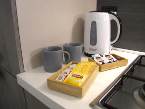 un bancone della cucina con due tazze e una scatola di formaggio di Vicenza City Apartments 1 a Vicenza