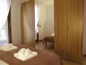 1 dormitorio con 2 toallas en la cama y espejo en Vicenza City Apartments 1, en Vicenza