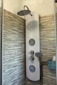 um chuveiro numa casa de banho com dois relógios na parede em Residence Villa Fiore Portorož em Portorož