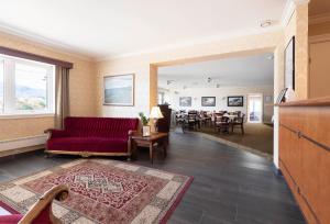 ein Wohnzimmer mit einem roten Sofa und einem Tisch in der Unterkunft Aursnes Hotell in Sykkylven