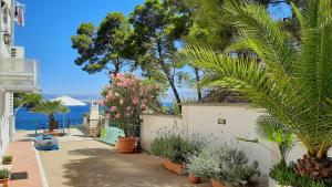 a garden with plants and trees and the water at Apartments Villa La Riva - Seafront accommodation in Sutivan