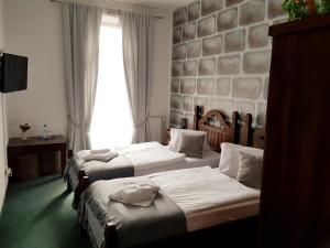 una camera d'albergo con due letti e una finestra di Hotel Camelot a Tisá