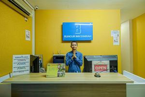 eine Anzeige in einem Raum mit einem Schild an der Wand in der Unterkunft Bungur Inn Syariah in Jakarta