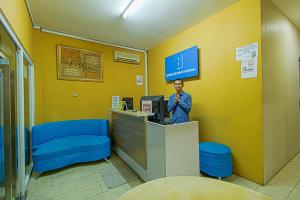 Ein Mann steht an einem Tresen in einem Laden. in der Unterkunft Bungur Inn Syariah in Jakarta