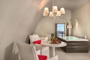 a living room filled with furniture and a large window at Mythical Blue Luxury Suites in Fira