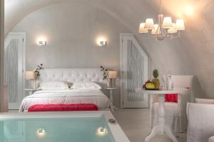 a bedroom with a bed and a bath tub at Mythical Blue Luxury Suites in Fira