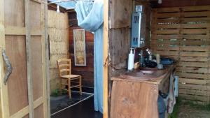 a bathroom with a sink in a wooden shed at Yourte et tente dans un écolieu avec piscine hors-sol in Péault