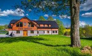 una casa en un campo verde con un árbol en Ranch Jestřebice en Heřmaničky