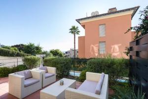 un patio con 2 sillas y una mesa y un edificio en Villa Rocky - Luxury 3BR Apt in Liberty Villa.Pool,Garden,WiFi, en Roquebrune-Cap-Martin