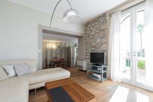 a living room with a white couch and a tv at Villa Rocky - Luxury 3BR Apt in Liberty Villa.Pool,Garden,WiFi in Roquebrune-Cap-Martin