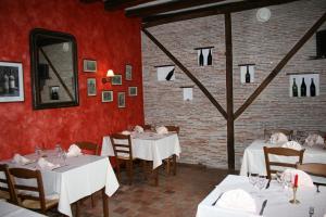 a restaurant with white tables and chairs and a mirror at La Ferme des 3 Maillets in Avaray
