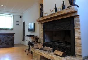 a living room with a fireplace and a television at Kalin Hotel in Lazaropole