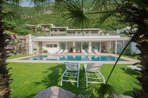 a house with a swimming pool and two lawn chairs at Hidalgo Suites in Postal