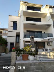a white building with potted plants in front of it at Apartment Rippl in Crikvenica