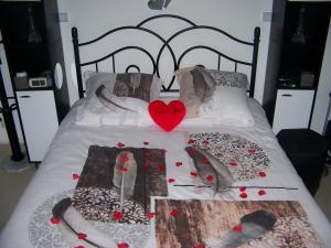 a bed with shoes and a heart on it at Charmant STUDIO au Calme Tout Confort Dans Château Néo Gothique proche ZENITH COMET ORLEANS Parking Voiture Gratuit WIFI Haut Débit Rue des Montées in Orléans