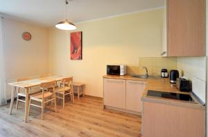 シュクラルスカ・ポレンバにあるApartamenty Sun Seasons 24 - Willa Laserのキッチン(テーブル、テーブル、椅子付)