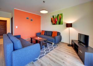 Sala de estar con 2 sofás azules y TV en Apartamenty Sun Seasons 24 - Willa Laser en Szklarska Poręba
