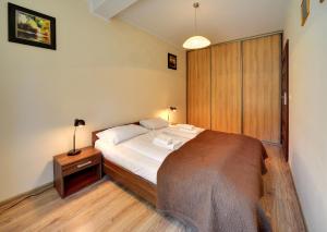 a bedroom with a large bed with a night stand and a bed sidx sidx sidx at Apartamenty Sun Seasons 24 - Willa Laser in Szklarska Poręba