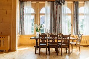 a dining room with a table and chairs and windows at Podhalańskie Tarasy - LoftAffair in Kościelisko