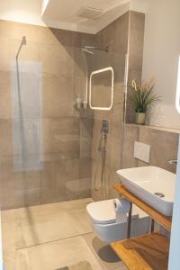 e bagno con doccia, servizi igienici e lavandino. di Soulfactory Apartments a Neu-Ulm