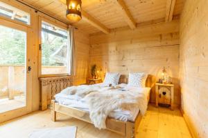 a bedroom with a bed in a log cabin at Podhalańskie Tarasy - LoftAffair in Kościelisko