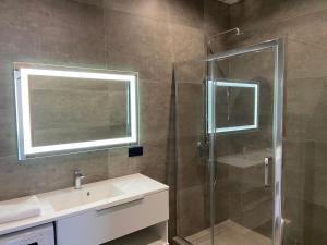 ein Badezimmer mit Glasdusche und Waschbecken in der Unterkunft New Coast Apartaments Odessa near sea in Odessa + 37 Fotos